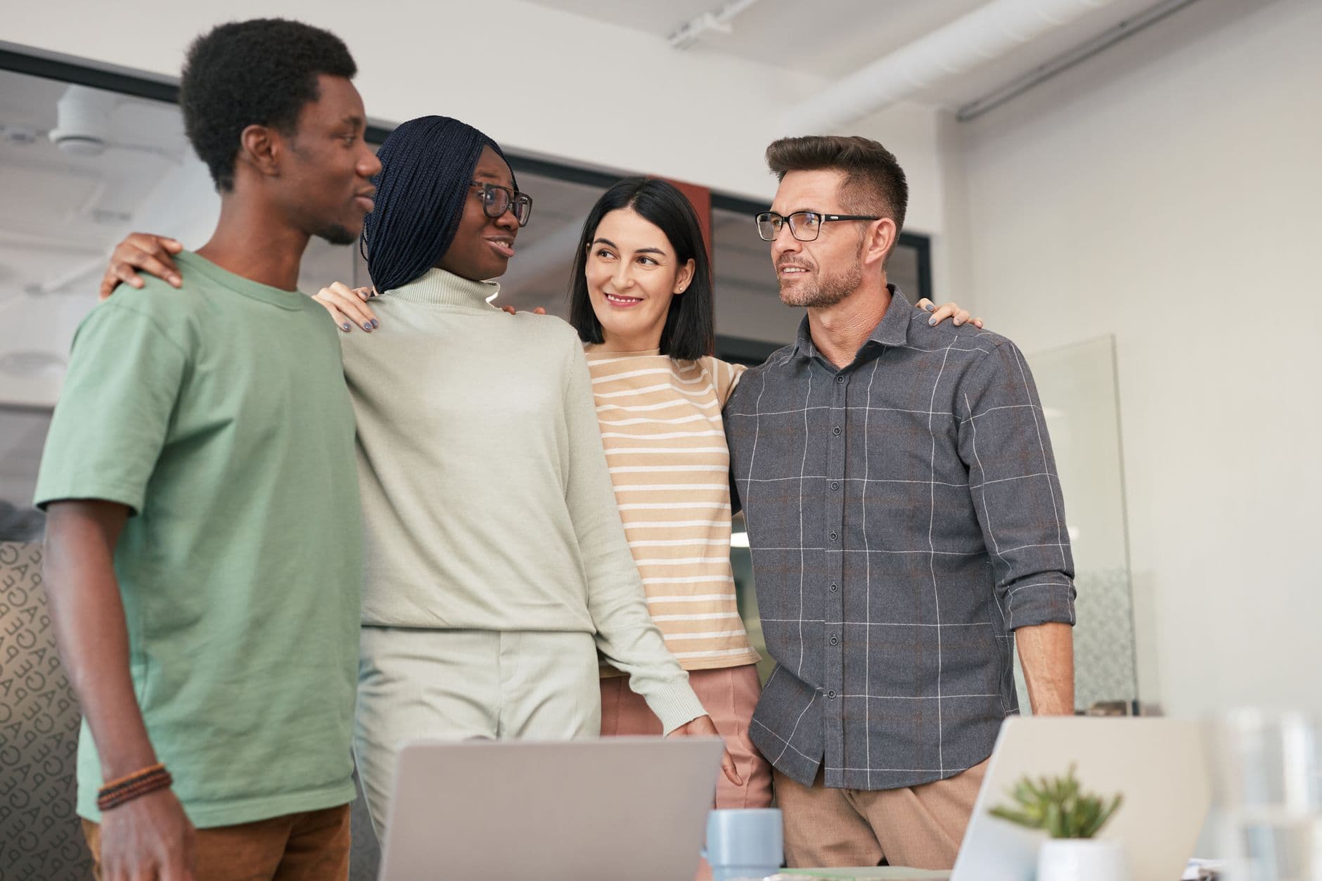 A small team standing together in their workspace