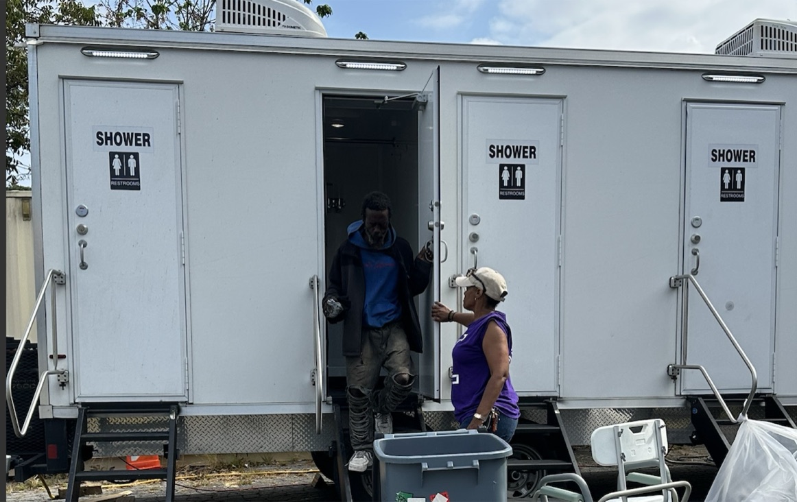 A neighbor steps out of the People Patch Mobile Showers trailer